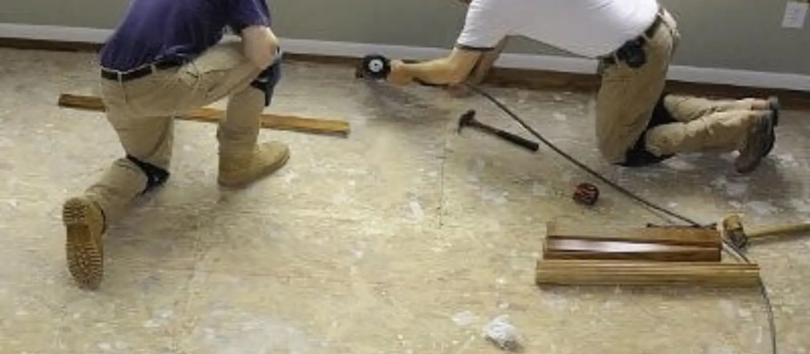 Two workers installing new flooring during a water damage rebuild